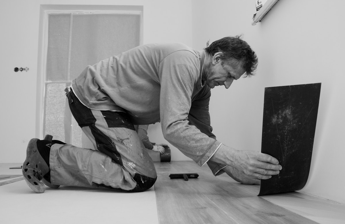 Flooring installer fitting plank in an unfinished room